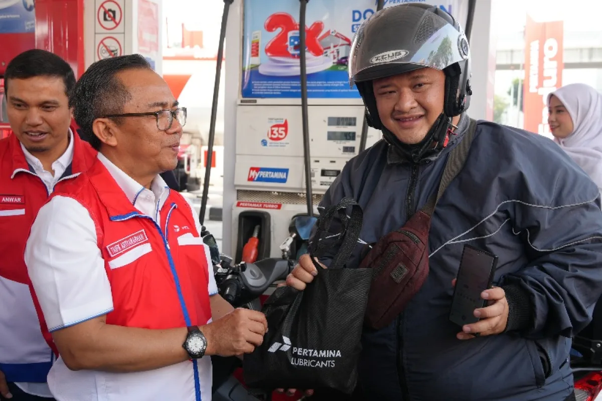 Taufik Adityawarman, Wakil Direktur Utama Pertamina Patra Niaga Subholding Downstream Pertamina (SHD), memberikan merchandise kepada pengendara kegiatan Sapa Pelanggan di SPBU Pertamina MT Haryono, Bekasi